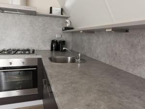 een keuken met een wastafel en een fornuis bij Holiday Home Emslandermeer by Interhome in Vlagtwedde