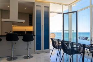 Beachfront Apartments- Horizon Residence في سارنده: مطبخ مع كراسي وطاولة مطلة على المحيط