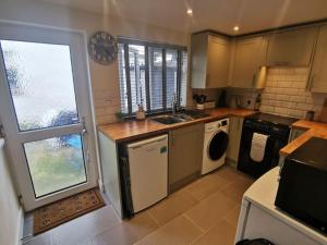 a kitchen with a sink and a dishwasher at Cosy Cottage in a quaint village in North Devon. in Bideford