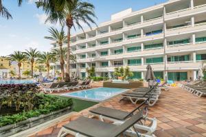 un hotel con piscina y tumbonas en Golden Sands Pool Apartment, en Playa del Inglés