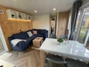 a living room with a blue couch and a table at Holiday Home Tiny Haus Anellie by Interhome in Riedenburg