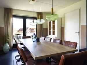 a dining room with a wooden table and chairs at Holiday Home Lieskehuis Wellness de Luxe 10-2 by Interhome in Vlagtwedde +30 photos
