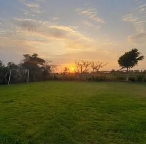 a sunset in a field with a soccer field at FINCA JAZMIN in Monsefú
