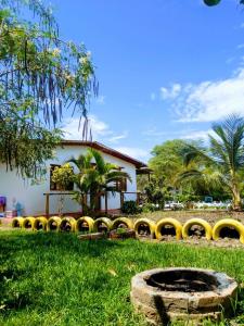 un bâtiment avec une clôture jaune dans l'herbe dans l'établissement FINCA JAZMIN, à Monsefú
