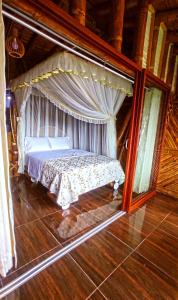 a bed in a room with a canopy at La Bella y El Leon in Tingo María