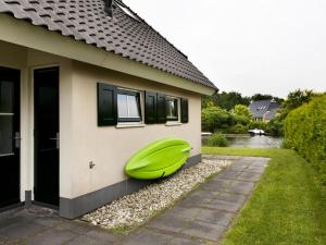 a green boat sitting on the side of a house at Holiday Home Heerd Wellness de Luxe by Interhome in Vlagtwedde