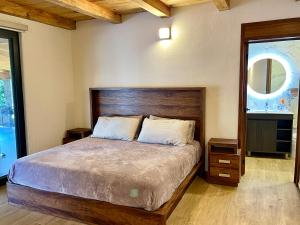 a bedroom with a large bed with a wooden headboard at Cabaña en Tapalpa, Cabaña Monarca in Tapalpa
