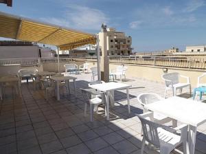 a patio with tables and chairs on a roof at le terrazze sul mare gallipoli in Gallipoli