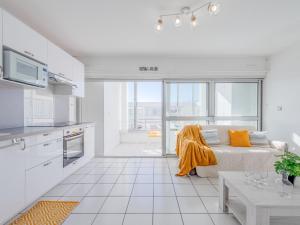 Una sala de estar blanca con una cama y una cocina. en Apartment Grand Bleu by Interhome, en Le Barcarès