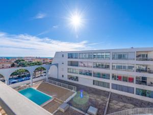 Un edificio de apartamentos con piscina enfrente. en Apartment Grand Bleu by Interhome, en Le Barcarès