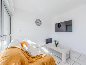 ein weißes Wohnzimmer mit einer Couch und einer Uhr an der Wand in der Unterkunft Apartment Grand Bleu by Interhome in Le Barcarès + 28 Fotos