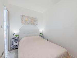 ein weißes Schlafzimmer mit einem Bett in einem Zimmer in der Unterkunft Apartment Grand Bleu by Interhome in Le Barcarès