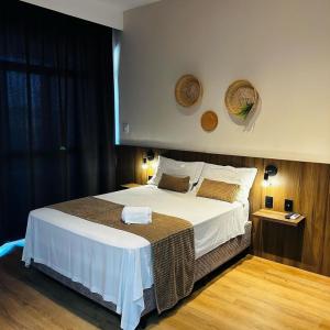 a bedroom with a large bed with two baskets on the wall at Recanto da Orla in Aracaju