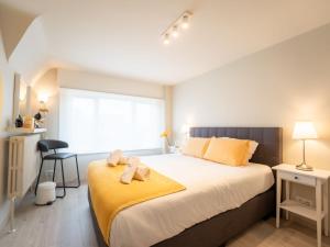 ein Schlafzimmer mit einem großen Bett mit zwei Teddybären darauf in der Unterkunft Villa Odyssee by Interhome in De Haan
