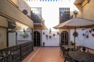 an outdoor patio with tables and an umbrella at Suites Sevilla in Puebla