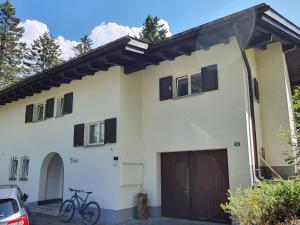 a white house with a bike parked in front of it at Apartment Ferienhaus Tina by Interhome in Lenzerheide