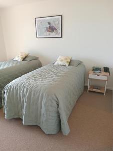 a bedroom with two beds and a table with a night stand at The Views in Dunedin