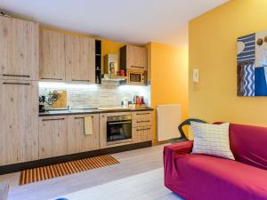 een keuken met gele muren en een rode bank in een kamer bij Apartment Welcome 2 Riva by Interhome in Riva del Garda