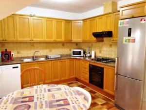 uma cozinha com armários de madeira e um frigorífico de aço inoxidável em Villa Villa Olivos by Interhome em L'Ametlla de Mar
