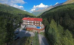 a large building with a red roof on a mountain at Bellavista Schönblick in Casere alte del Piano