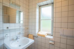 a white bathroom with a sink and a window at Bellavista Schönblick in Casere alte del Piano