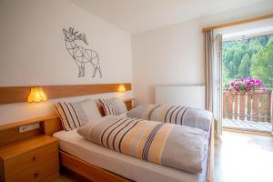 dwa łóżka w pokoju z oknem w obiekcie Bellavista Schönblick w mieście Casere alte del Piano
