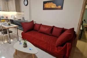 a living room with a red couch and a table at M&S Apartments Athens in Athens