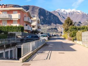 une rue avec des voitures garées et des montagnes en arrière-plan dans l'établissement Apartment Garden Apartment by Interhome, à Riva del Garda