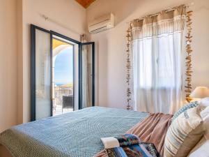 a bedroom with a bed and a large window at Apartment Mahalo by Interhome in La Ciaccia