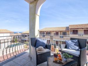 a patio with two chairs and a table on a balcony at Apartment Mahalo by Interhome in La Ciaccia