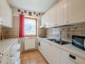 una cucina con armadi bianchi, lavandino e finestra di Apartment Mason Scarzin by Interhome ad Alba di Canazei