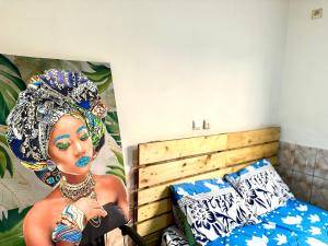 1 dormitorio con 1 cama y una pintura de una mujer en Huge apartment in Yaoundé, en Yaoundé