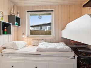 Ce lit se trouve dans un dortoir doté d'une fenêtre. dans l'établissement Holiday Home Gyrid - 150m from the sea in Djursland and Mols by Interhome, à Rønde