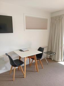 ein Wohnzimmer mit einem Tisch und 2 Stühlen in der Unterkunft The Views in Dunedin