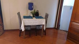 a table and chairs with a table and a vase on it at Cabañas Hua'ai Village in Hanga Roa