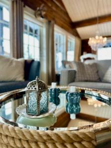 Fantastic cabin on Hafjell ski inout في هافيل: غرفة معيشة مع طاولة زجاجية عليها فانوس