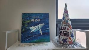 une peinture d'une baleine et d'un chapeau d'anniversaire dans l'établissement Casamigalu, à Séoul