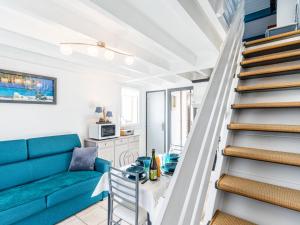 Una sala de estar con un sofá azul y escaleras. en Apartment Moulin de la Brunette-4 by Interhome, en Vaux-sur-Mer 21 fotos más