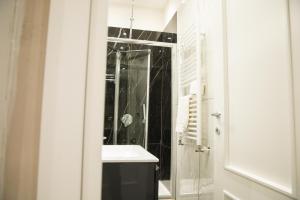 ein Bad mit einem Waschbecken und einer Glasdusche in der Unterkunft Residence Black & White in Neapel
