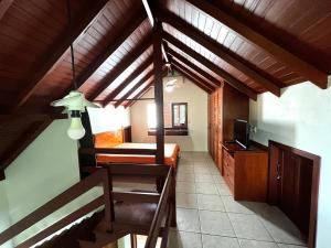 Pousada Residência Nativa في بينيرا: غرفة بها درج مع سرير وتلفزيون