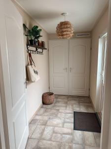um corredor com uma porta branca e um piso em Luxe Chalet De Bosrand Dichtbij Zee em Sint-Annaland