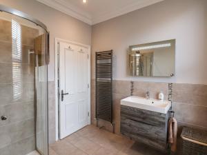 a bathroom with a sink and a shower and a mirror at 11 Highfield in Scarborough