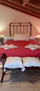 1 dormitorio con cama roja y almohadas blancas en A1 Allagar derecha, en Sales