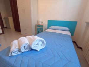 een slaapkamer met 2 handdoeken op een blauw bed bij Appartamento al mare civico28 in Porto Recanati
