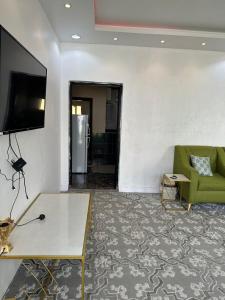 a living room with a couch and a tv on a wall at شاليه قلب الهدا 3-4 in Al Hada