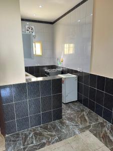 a kitchen with black and white tiles on the wall at شاليه قلب الهدا 3-4 in Al Hada