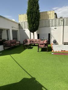 a yard with two couches and a tree at شاليه قلب الهدا 3-4 in Al Hada