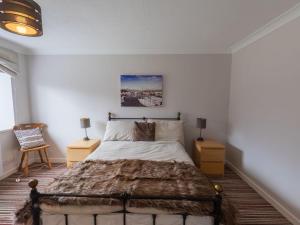 a bedroom with a large bed with two night stands at Holiday Home Stable Cottage by Interhome in Drumnadrochit