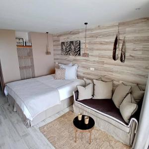 勒迪亚芒Ma place au Soleil, l'Escapade romantique的一间卧室配有一张床和一张沙发