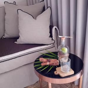 勒迪亚芒Ma place au Soleil, l'Escapade romantique的一张桌子,上面有一瓶,一张玻璃放在沙发上